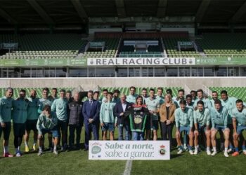 Plantilla del Real Racing Club posando en el estadio El Sardinero junto a directivos y representantes institucionales durante un acto promocional, con el cartel "Sabe a norte, sabe a ganar" en primer plano.