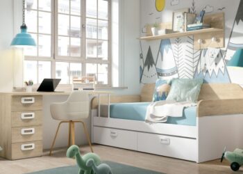 Dormitorio infantil moderno y luminoso con cama nido, escritorio de madera clara con silla blanca, estantería con juguetes y decoración mural de montañas, todo en tonos suaves y estilo escandinavo.
