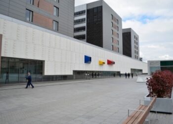 Fachada principal del Hospital Universitario Marqués de Valdecilla en Santander, con varios transeúntes, en el contexto de las movilizaciones sindicales por la igualdad en la sanidad pública cántabra.