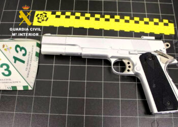 Pistola incautada sobre una mesa, utilizados en el asalto a un establecimiento en Santander, donde un detenido amenazó a los empleados para llevarse la recaudación.